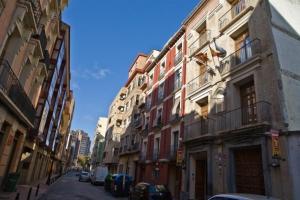 a city street with buildings and cars parked on the street at Be Zaragoza Hostel in Zaragoza