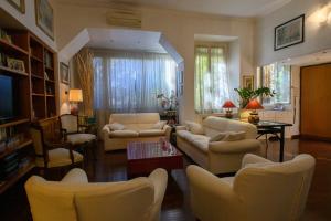 a living room with couches and chairs and a tv at Apartment Roma Deluxe in Rome