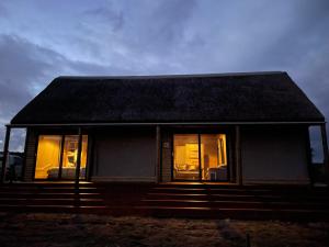 una piccola casa con tetto e finestre scuri di Kuierbos a Gouritzmond