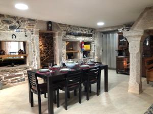 a dining room with a black table and chairs at Casa do Grallo in Corcoesto