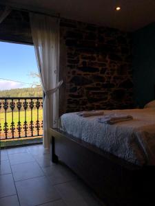 a bedroom with a bed and a window with a view at Casa do Grallo in Corcoesto