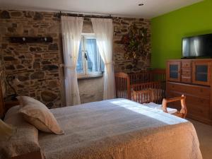 um quarto com uma cama grande e uma parede de pedra em Casa do Grallo em Corcoesto