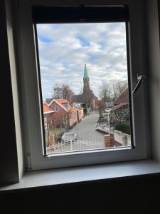 a window with a view of a town with a church at Torenzicht in Kapelle