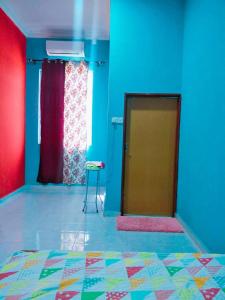 um quarto com paredes azuis e vermelhas e uma porta em Sobey Laris Homestay KAYDEE em Pasir Mas