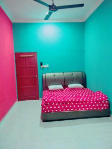um quarto com uma cama vermelha e uma porta vermelha em Sobey Laris Homestay KAYDEE em Pasir Mas