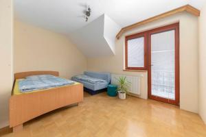 a bedroom with a bed and a couch and a window at Apartma Ana in Preserje