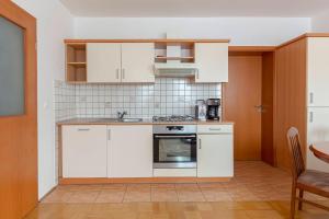 a kitchen with white cabinets and a stove top oven at Apartma Ana in Preserje