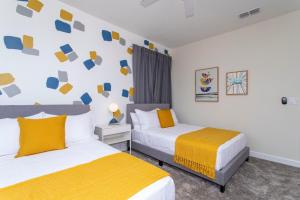 two beds in a room with yellow and blue at Stunning 5 Bd w/ Pool Close to Disney @ Storey Lake 2767 in Kissimmee