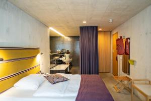 a bedroom with a bed and a woman in a bathroom at Nomad Design & Lifestyle Hotel in Basel
