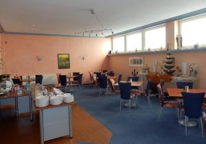 a dining room with tables and chairs and windows at Park Hotel in Schweinfurt