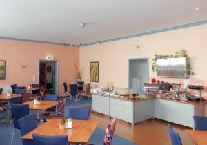 a restaurant with wooden tables and blue chairs at Park Hotel in Schweinfurt
