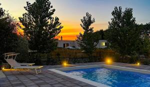 a swimming pool with a lounge chair and a chair at Oltre la Vite in Selva di Fasano