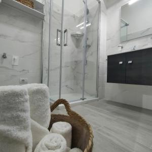 a bathroom with a shower and a basket of towels at Oltre la Vite in Selva di Fasano