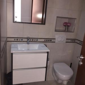 ein Badezimmer mit einem weißen Waschbecken und einem WC in der Unterkunft L'appartement Bella Vista - Vue panoramique sur la Méditerranée WIFI in Cabo Negro