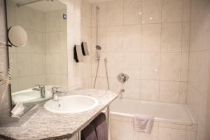 a bathroom with a sink and a bath tub at Park Hotel in Schweinfurt