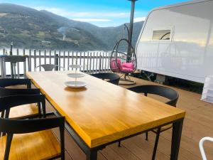 a wooden table and chairs on a deck with a van at Casa Entera in Hualing