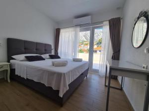 1 dormitorio con 1 cama grande y ventana grande en Apartments FIGA, en Orebić