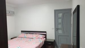 a bedroom with a bed with pink sheets and a door at شقة على كورنيش النيل المعادي Maadi Nile view Cairo in Al Ma‘şarah