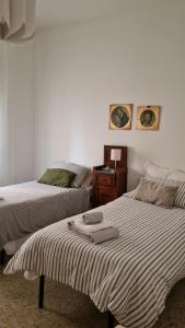 - une chambre avec 2 lits et une table de chevet avec une sidx dans l'établissement Come a casa, à Tognazza