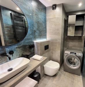uma casa de banho com um lavatório e uma máquina de lavar roupa em PM. Apartments Krakow na Cracóvia