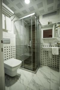 y baño con ducha, aseo y lavamanos. en Narcis Apart Hotel, en Alanya