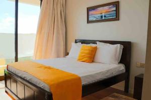 een slaapkamer met een bed met een oranje kussen erop bij Joe Apartments in Syokimau