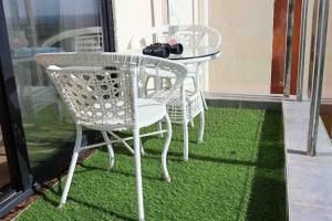 einen Tisch und Stühle auf einem Balkon mit grünem Gras in der Unterkunft Joe Apartments in Syokimau