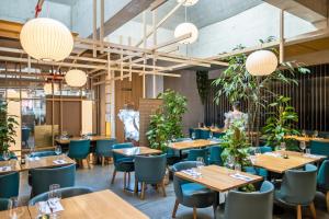 un restaurante con mesas de madera y sillas azules en Nomad Design & Lifestyle Hotel en Basilea