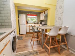 a kitchen with a table and chairs in a room at The Hollies in Prestatyn