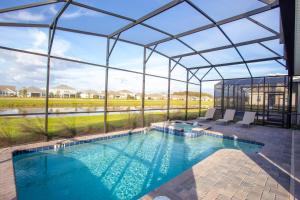 een zwembad in een glazen huis met uitzicht bij Stunning 8 Bd w/ Pool Close to Disney 2887 in Kissimmee