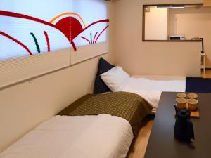 2 letti in una piccola camera con finestra di ASAKUSAーHANAKAWADO a Tokyo