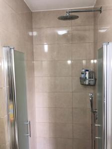 a shower with a glass door in a bathroom at Bat Galim - by the sea in Haifa