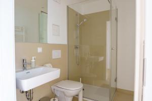 a bathroom with a shower and a toilet and a sink at Central Living Apartments - Belvedere in Vienna