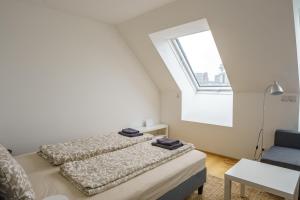 two beds in a white room with a window at Central Living Apartments - Belvedere in Vienna