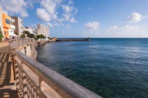 a view of the ocean from a pier with buildings at Casa Andrea Doria Arinaga in Arinaga