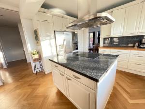 a kitchen with white cabinets and a black counter top at Big Villa centrally located in Reykjavik in Reykjavík