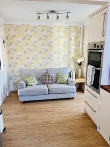 a living room with a blue couch in a kitchen at Cosy 3-bed house in Hull