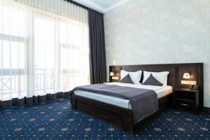 a bedroom with a bed and a large window at Amberd Hotel in Byurakan