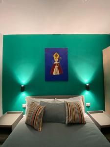 een slaapkamer met een groene muur en een bed bij 2Naples Rooms in Napels