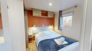 Un dormitorio pequeño con una cama y una ventana. en Mobil home domaine avec piscine proche mer, en La Parée Preneau 32 fotos más