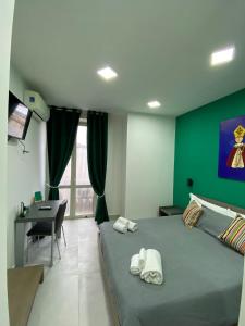 een slaapkamer met een bed met een groene muur bij 2Naples Rooms in Napels