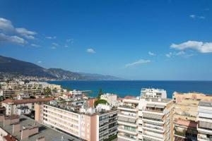 a view of a city with the ocean and buildings at Appartement T2 en bord de mer in Roquebrune-Cap-Martin
