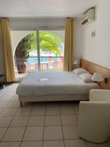 Un dormitorio con una cama y vista a un patio. en Hotel Résidence Anglet Biarritz-Parme, en Anglet 56 fotos más