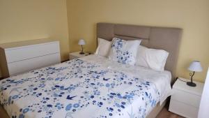 een slaapkamer met een bed met blauwe bloemen erop bij Lombada House in Ponta Delgada