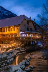 a hotel with a bridge over a river at night at Logis Hôtel et Spa Le Christiania in La Salle-les-Alpes