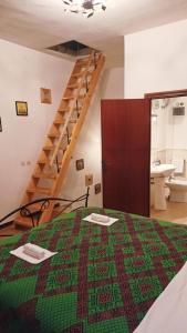 1 dormitorio con 1 cama con edredón verde y rojo en La casa di sally en Pitigliano