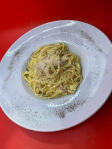 a plate of pasta on a red table at PIZZERIA RUSTICA cazare in Borşa +19 photos