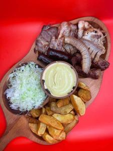 un piatto di alimenti con carne e verdure su un tavolo di Rustica Complex Borsa a Borşa