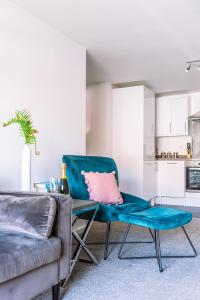 uma sala de estar com um sofá e uma almofada cor-de-rosa numa cadeira em 2 Bed Boutique Apartment with free parking em York