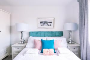 um quarto com uma cama com almofadas cor-de-rosa e azuis em 2 Bed Boutique Apartment with free parking em York